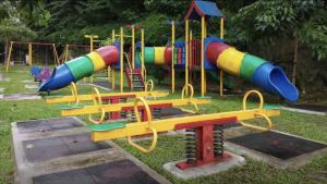 a playground with a colorful slide in the grass at Taiping Rain Town Homestay太平雨城名宿 two car park in Taiping