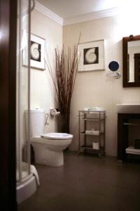 a bathroom with a toilet and some pictures on the wall at Vanilla Hotel in Lublin +45 photos