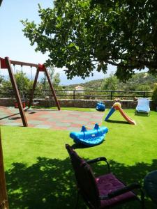 einen Hof mit einem Spielplatz mit Schaukel in der Unterkunft Fissi Villas agritourism accommodation near the sea in Agios Nikolaos