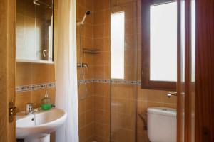 ein Bad mit einem Waschbecken, einem WC und einem Fenster in der Unterkunft El Refugi de les Basses Apartament in Campelles