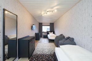 Zimmer mit einem Spiegel, einem Bett und einem Sofa in der Unterkunft Ferienhaus Wehlener Rosengarten in Bernkastel-Kues