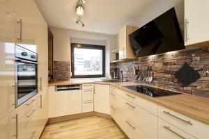 a kitchen with white cabinets and a window and a sink at Ferienhaus Wehlener Rosengarten in Bernkastel-Kues