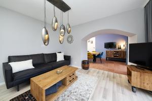 a living room with a black couch and a tv at Ferienhaus Wehlener Rosengarten in Bernkastel-Kues