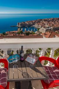 a table with two glasses of wine on a balcony at Amazing view Apartments Dijana in Dubrovnik