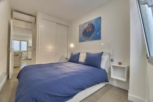 sypialnia z niebieskim łóżkiem w białym pokoju w obiekcie Malibú Canteras nº 1 - Planta Baja - Ground Floor w mieście Las Palmas de Gran Canaria