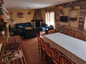 a kitchen and living room with a table and chairs at Los Alisos Casa Rural in Guadalix de la Sierra