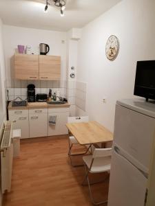 eine Küche mit einem Tisch und eine kleine Küche mit weißen Schränken in der Unterkunft SchlafSchön Apartments+Monteurzimmer in Böhlen