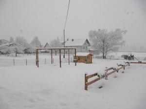 ein schneebedecktes Feld mit einem Zaun in der Unterkunft Landhaus Obervellach in Hermagor