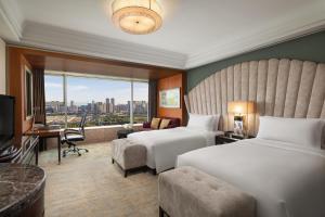 a hotel room with two beds and a large window at InterContinental Century City Chengdu, an IHG Hotel in Chengdu