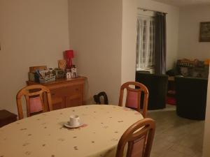 Una mesa y sillas en una sala de estar con una taza de café. en Appartement d'hôtes An Kaz La, en Crans-Montana