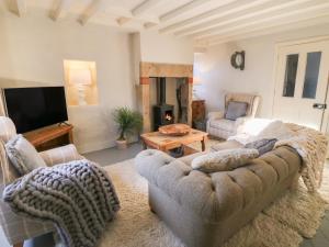 a living room with a couch and a tv at Coupling Cottage in Belper