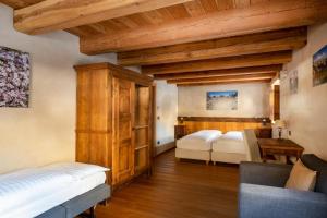 two beds in a room with wooden ceilings at Albergo Locanda Mistral in Acceglio