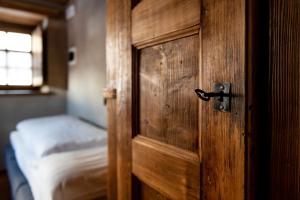 eine Holztür in einem Zimmer mit einem Bett in der Unterkunft Albergo Locanda Mistral in Acceglio