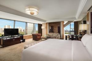 a bedroom with a large bed and a living room at InterContinental Century City Chengdu, an IHG Hotel in Chengdu