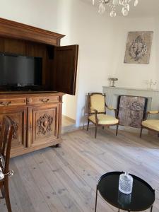 - un salon avec une télévision, une table et des chaises dans l'établissement Charmant appartement dans un immeuble du 15ème siecle, à Sartène