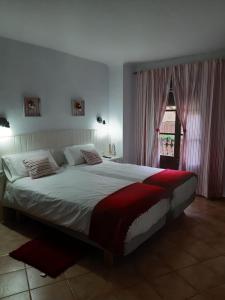 um quarto com uma cama grande e uma janela em L'Hostalet em Arboli