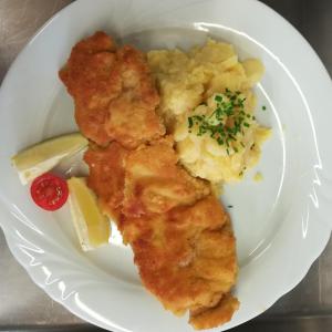 a white plate with a piece of fish and potatoes at Zum Goldenen Schwanen in Frankenried