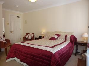 a bedroom with a large bed with a red blanket at Tyrrells Ford Hotel in Christchurch