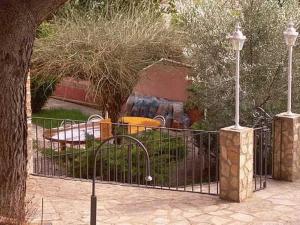 une porte en fer forgé avec une aire de jeux derrière elle dans l'établissement Villa Pachita, à Alhama de Aragón