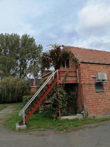 een rode trap aan de zijkant van een bakstenen huis bij Studio with More than a View in Maldegem