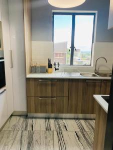 uma cozinha com armários de madeira e uma grande janela em Musgrave Seafern em Durban