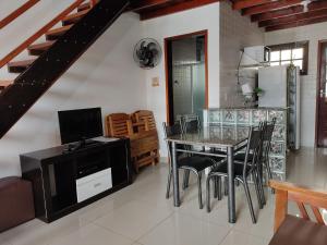a kitchen and dining room with a table and chairs at Apartamento em Ubatuba in Ubatuba