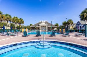 a swimming pool with chairs and a resort at Disney Townhouse with Themed Room in Kissimmee