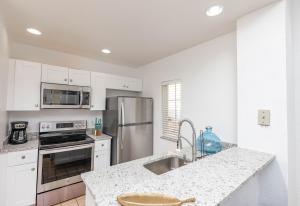 a kitchen with white cabinets and stainless steel appliances at Disney Townhouse with Themed Room in Kissimmee