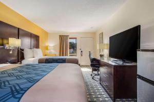 a hotel room with two beds and a flat screen tv at Econo Lodge North Charleston in Charleston