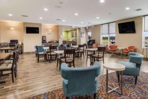 uma sala de espera com mesas e cadeiras e uma cafetaria em MainStay Suites em Union City