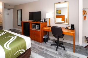a hotel room with a bed and a desk with a computer at Quality Inn Miami Airport - Doral in Miami