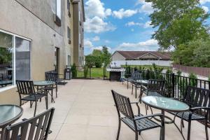 a patio with tables and chairs and a grill at Comfort Suites Auburn near I-69 in Auburn