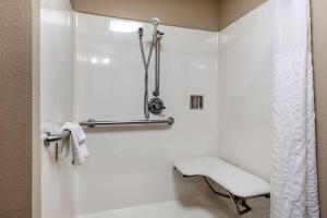 a white bathroom with a bench and a shower at Comfort Inn & Suites Pauls Valley - City Lake in Pauls Valley