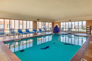 a large swimming pool with blue chairs in a building at Comfort Inn & Suites Pauls Valley - City Lake in Pauls Valley