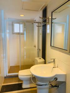 a bathroom with a toilet and a sink and a shower at Likas Square - KK Spacious Homestay in Kota Kinabalu