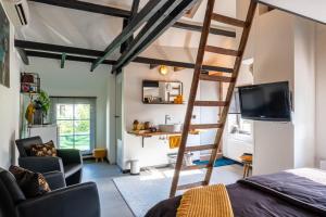 a room with a loft bed and a television at Den oude Herberg in Hulsberg