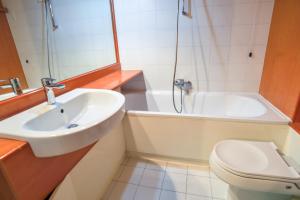 łazienka z umywalką, toaletą i wanną w obiekcie Residence Artuik Appartamenti Solandra w mieście Marilleva