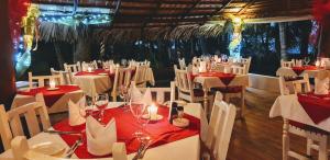a dining room with white tables and white chairs at Atlantis Hotel in Las Terrenas