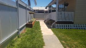 a sidewalk next to a house with a fence at Alkion Villa in Wagga Wagga