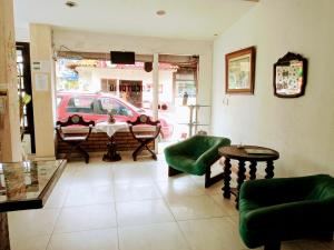 - un salon avec une table, des chaises et une voiture dans l'établissement Pousada Mandala, à Búzios