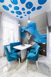 comedor con mesa y sillas azules en Rynok Square city center two bedroom apartment!, en Leópolis
