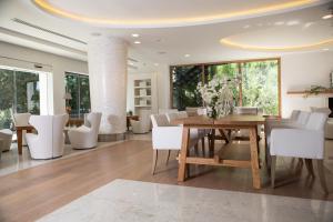a dining room with a wooden table and white chairs at Alasia Boutique Hotel in Limassol