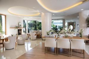 a dining room with a table and white chairs at Alasia Boutique Hotel in Limassol