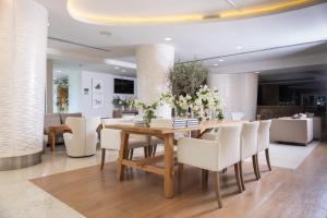 a dining room with a wooden table and white chairs at Alasia Boutique Hotel in Limassol