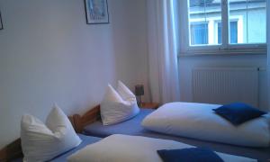 2 camas con almohadas en una habitación con ventana en Ferienwohnung - Ferien in der Grub, en Lindau