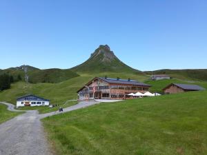 a building on a hill with a mountain in the background at Ferienwohnung Schnetzer Au in Au im Bregenzerwald