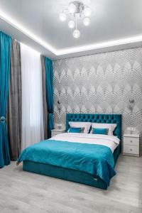 a bedroom with a blue bed with a blue headboard at Rynok Square city center two bedroom apartment! in Lviv