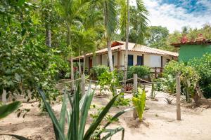ein Haus inmitten eines Gartens mit Bäumen in der Unterkunft Pousada Luar das Águas in Ilha de Boipeba