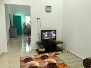 a living room with a television and a rug at Homestay Warisan Nenda in Shah Alam
