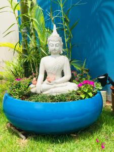 a statue of aitating buddha in a garden at Pousada Cielo Blu in Búzios